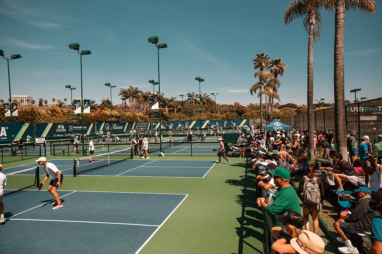 Players enjoying doubles pickleball on outdoor courts at Newport Beach